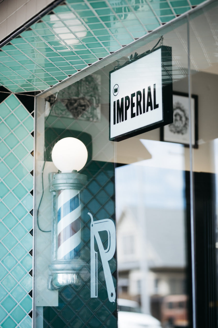 Imperial sign and barber pole behind the shop window