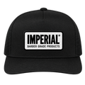 Front view of a black Imperial Barber Grade Products trucker hat with a rectangular woven patch bearing the Imperial Barber Grade Products logo in black on white.