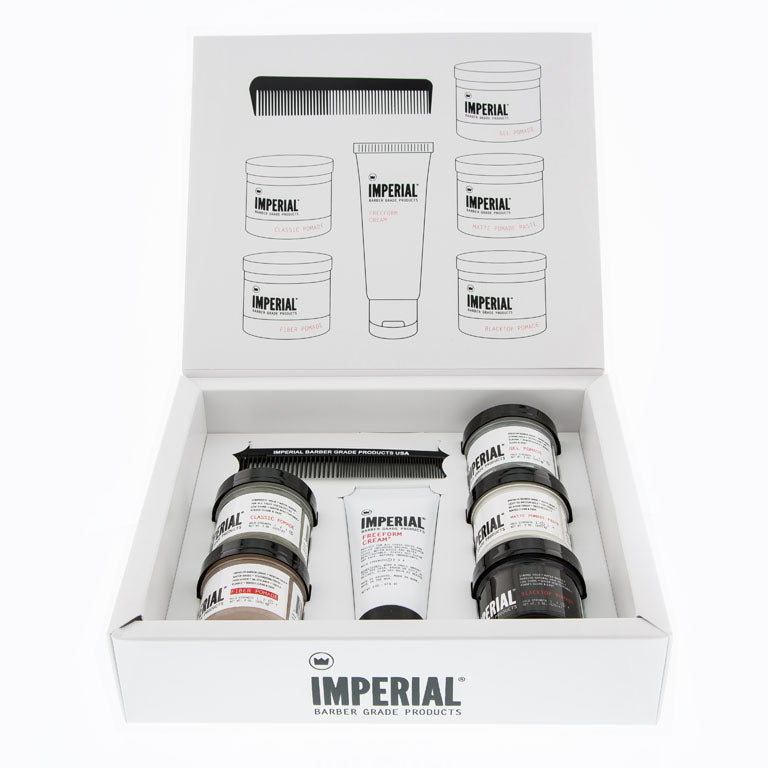 Imperial Barber Grade Products Travel Assortment box open from above, showing six mini pomade tubs, a tube of Freeform Cream, and a pocket comb nestled inside.